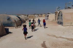 Children run between tents in a camp for displaced people in northwest Syria