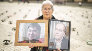 Fadwa holding photos of her son and husband at a protest marking the international day of the disappeared